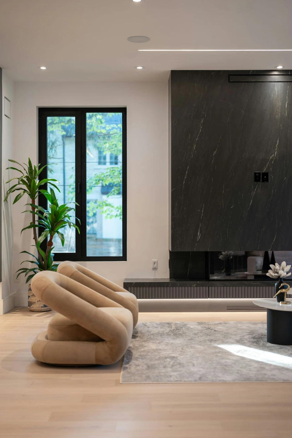 Modern interieur met grote ramen, sfeervolle verlichting en comfortabele zithoek.