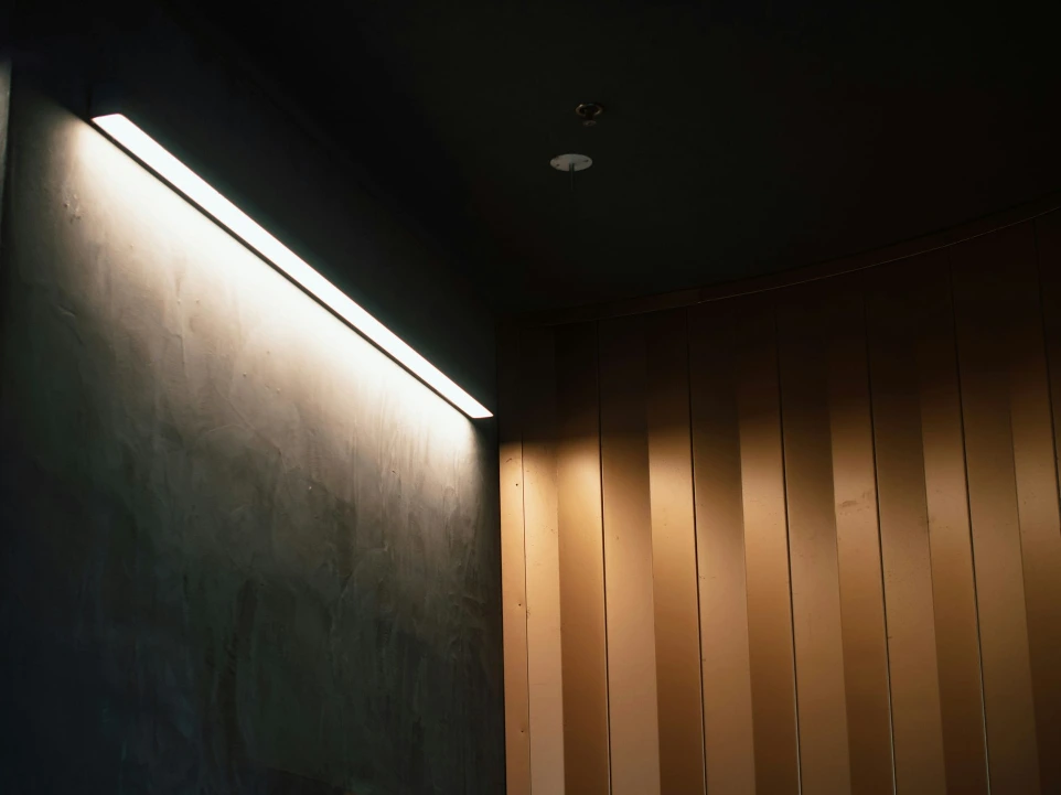 Indirecte sfeerverlichting geïntegreerd in een moderne houten wandafwerking.